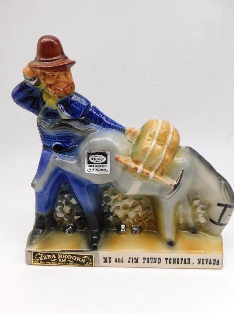 Ezra Brooks Me and Jim Found Tonopah Nevada Prospector and Burro Decanter: A capital Ezra Brooks decanter modeled as a bearded prospector shading his eyes beside his laden pack burro the ore at their feet picked out in ochre and cream. The base is lettered Me and Jim Found
