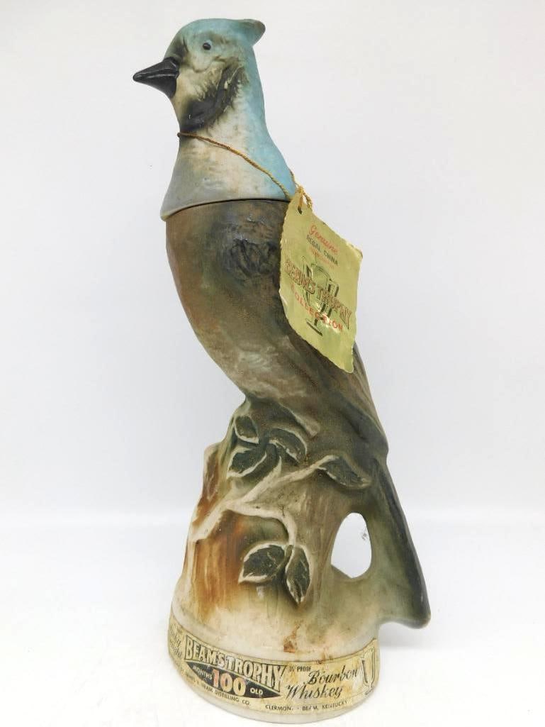 Jim Beam Regal China Blue Jay Trophy Collection Decanter with Hangtag: A Jim Beam Genuine Regal China decanter from Beam's Trophy Collection sculpted as a blue jay perched upon a leafy branch. The paint is lively and the bird well observed. Retains its original hangtag