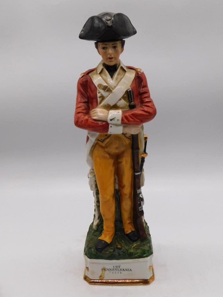 Grenadier 1st Pennsylvania 1775 Continental Soldier Decanter Seal Intact: A stately Grenadier Spirits Co. decanter modeled as a soldier of the 1st Pennsylvania 1775 standing at ease in scarlet coat and buff breeches with musket at his side. The hand painting is uncommonly f