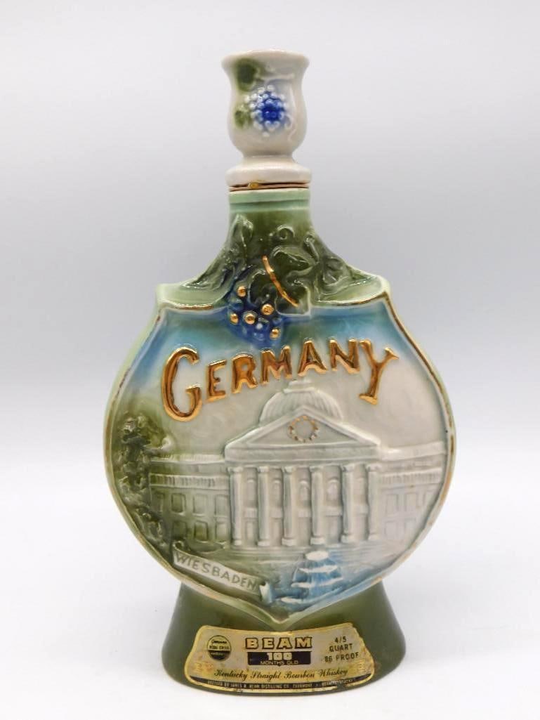Jim Beam Wiesbaden Germany Souvenir Decanter Regal China: A Jim Beam Regal China decanter commemorating Wiesbaden Germany its relief building design set against a blue-green ground with Germany embossed in gold lettering. Finished with a floral porcelain sto