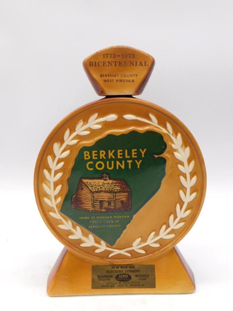 Old Mr. Boston Berkeley County West Virginia Bicentennial Decanter: An amber and gilt ceramic decanter by Old Mr. Boston commemorating the 1772-1972 Bicentennial of Berkeley County West Virginia. A log cabin medallion sits within a wheat-leaf wreath inscribed Home of 