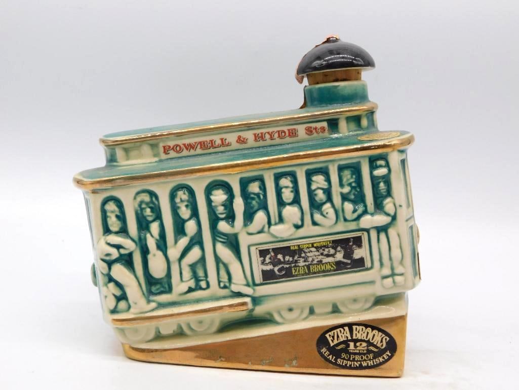 Ezra Brooks San Francisco Cable Car Powell and Hyde Decanter: An Ezra Brooks decanter modeled as a San Francisco cable car crowded with riders lettered Powell & Hyde Sts. across the roof board and trimmed throughout in gold. The gripman at his post serves as the