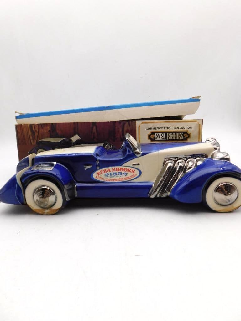 Ezra Brooks Commemorative Collection Blue Speedster Decanter with Original Box: A rakish Ezra Brooks decanter modeled as a boattail speedster in cobalt and cream with chromed exhaust pipes swept from the hood whitewall tires and a raked windscreen. The glaze is deep and the brigh