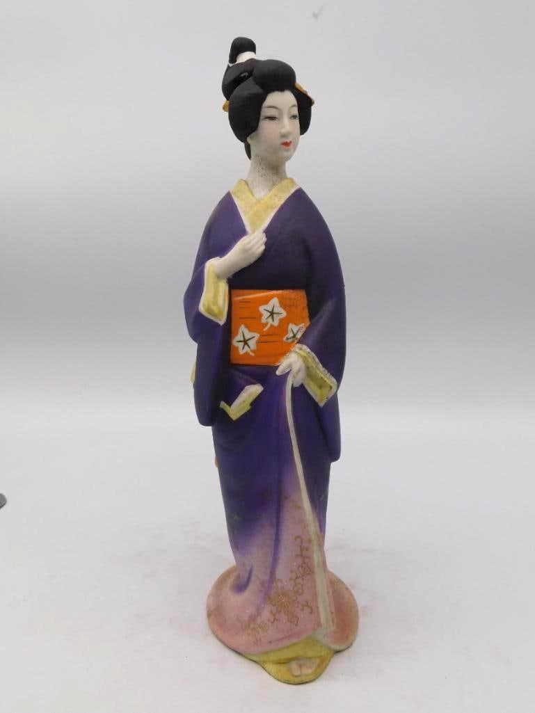 Japanese Lady in Kimono Bisque Whiskey Decanter Unmarked: A well-turned bisque decanter modeled as a Japanese lady standing in a violet kimono an orange obi at her waist painted with blossoms and reeds. The hair is dressed high and pinned the face finely