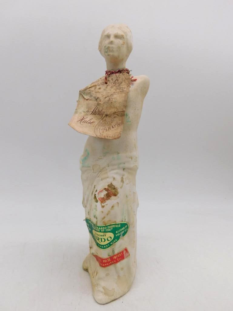 Luxardo Cherry Wine Venus de Milo Bottle with 1964 Gift Tag: An Italian bottle modeled after the Venus de Milo cast in a white bisque-look finish with draped robes falling to the foot. The front label names Luxardo of Torreglia Italy pride of Italy cherry wine 