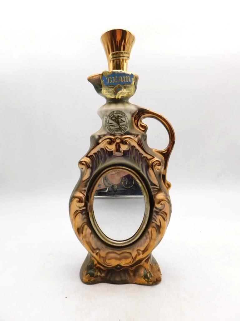 Jim Beam 180 Months Old Scroll-Design Regal China Ewer Decanter: A handsome Jim Beam Regal China ewer worked with raised acanthus scrolls in a green and gold lustre finish the neck label marked 180 Months Old and the gold-tone stopper lettered Turn to Open. Some