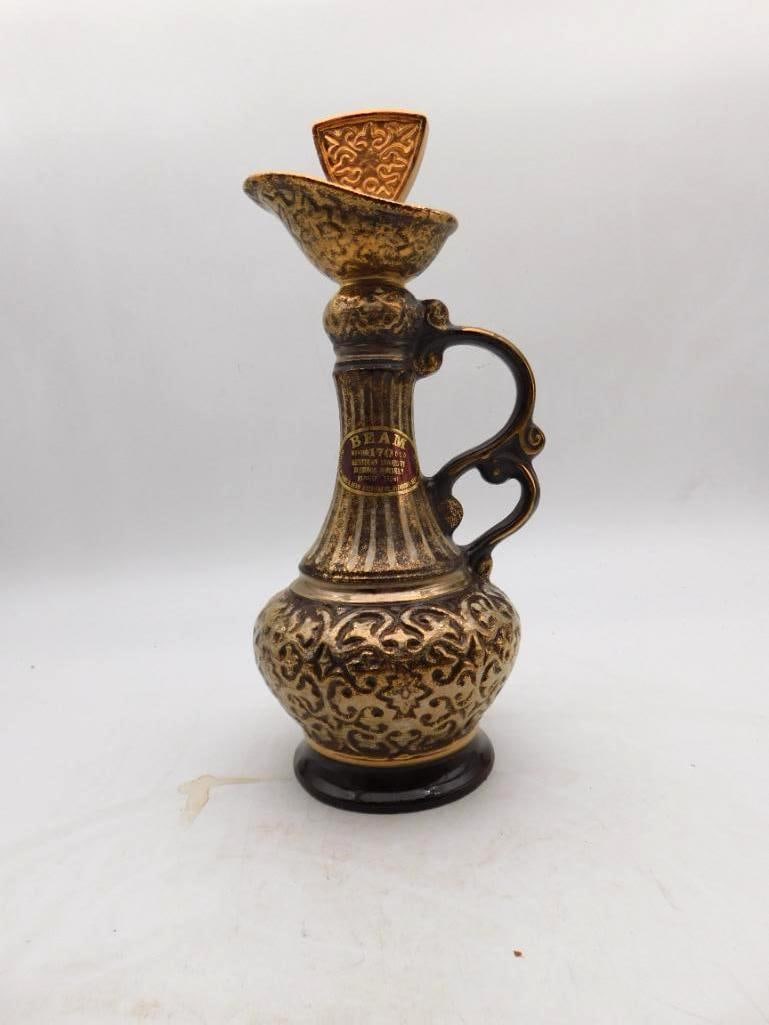 Jim Beam Regal China Gold Filigree Ewer Decanter with Scrolled Handle: A capital Jim Beam Regal China ewer in a dark tobacco glaze laid thick with gold arabesque the ovoid body and fluted neck banded in gilt and finished with a scrolled handle and a pierced gilt stopper.