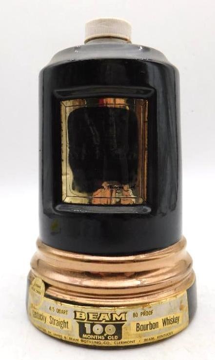 Jim Beam Ship's Lantern Black and Gold Regal China Decanter Seal Intact: A Jim Beam Regal China decanter styled as a ship's lantern in black and gold marked 100 Months Old Kentucky Straight Bourbon Whiskey. A Seal Intact tag indicates it has never been opened and the origi