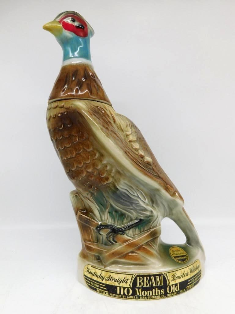 Jim Beam Regal China Ring-Necked Pheasant Decanter Seal Intact: A Jim Beam Regal China decanter modeled as a ring-necked pheasant perched on a log base the head plumage vivid in blue and red. The painter did not stint on the feather detail. Approximately 12.5 inch