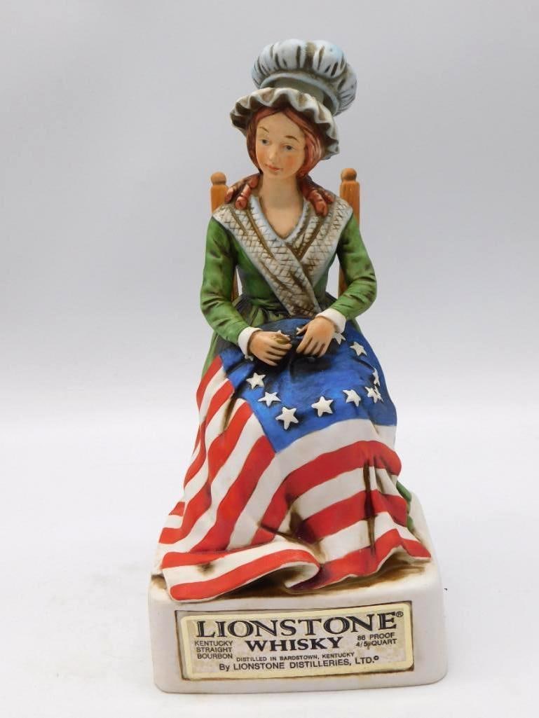 Lionstone Betsy Ross Bicentennial Series Bisque Decanter Seal Intact: A bisque porcelain Lionstone whiskey decanter rendered as Betsy Ross seated at her chair stitching the first American flag. The base is titled Betsy Ross 1752-1836 Bicentennial Series. An earnest subj