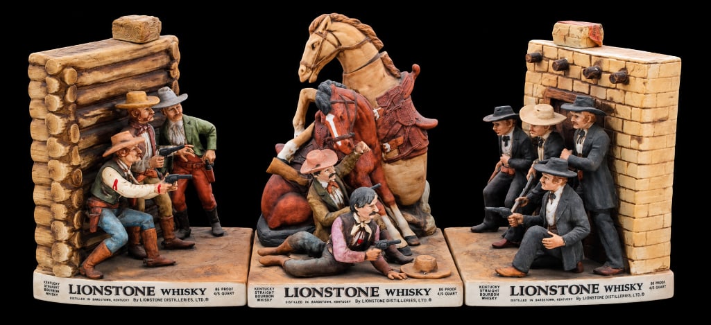 Lionstone Shootout at the OK Corral Bookend Decanter Set Plus Cowboy Decanter Set of 3: This lot brings together three Lionstone Kentucky Straight Bourbon Whisky decanters with an Old West theme. Two form a matched bookend-style pair depicting the 'Shootout at the OK Corral': Part 1 show