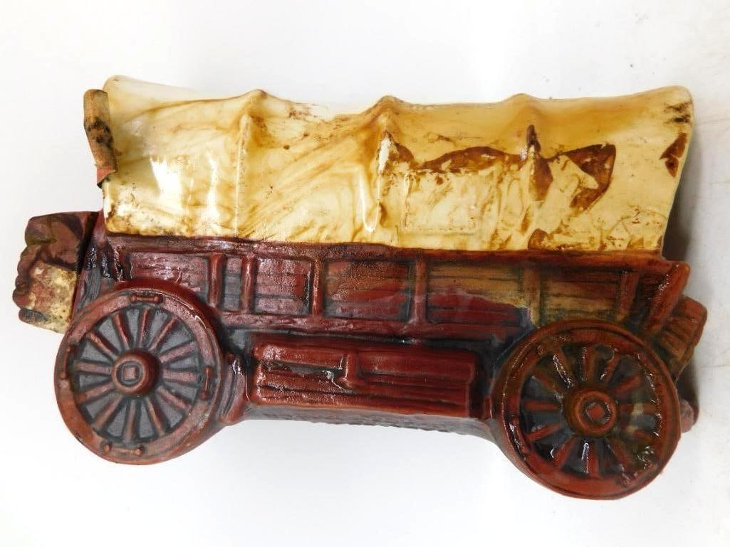 Sculpted Covered Wagon Old West Pioneer Decanter Seal Intact: A homespun decanter modeled as a covered wagon of the emigrant trail the canvas top glazed in cream and the running gear and spoked wheels in oxblood red. The mold-maker gave the boards bolts and hub