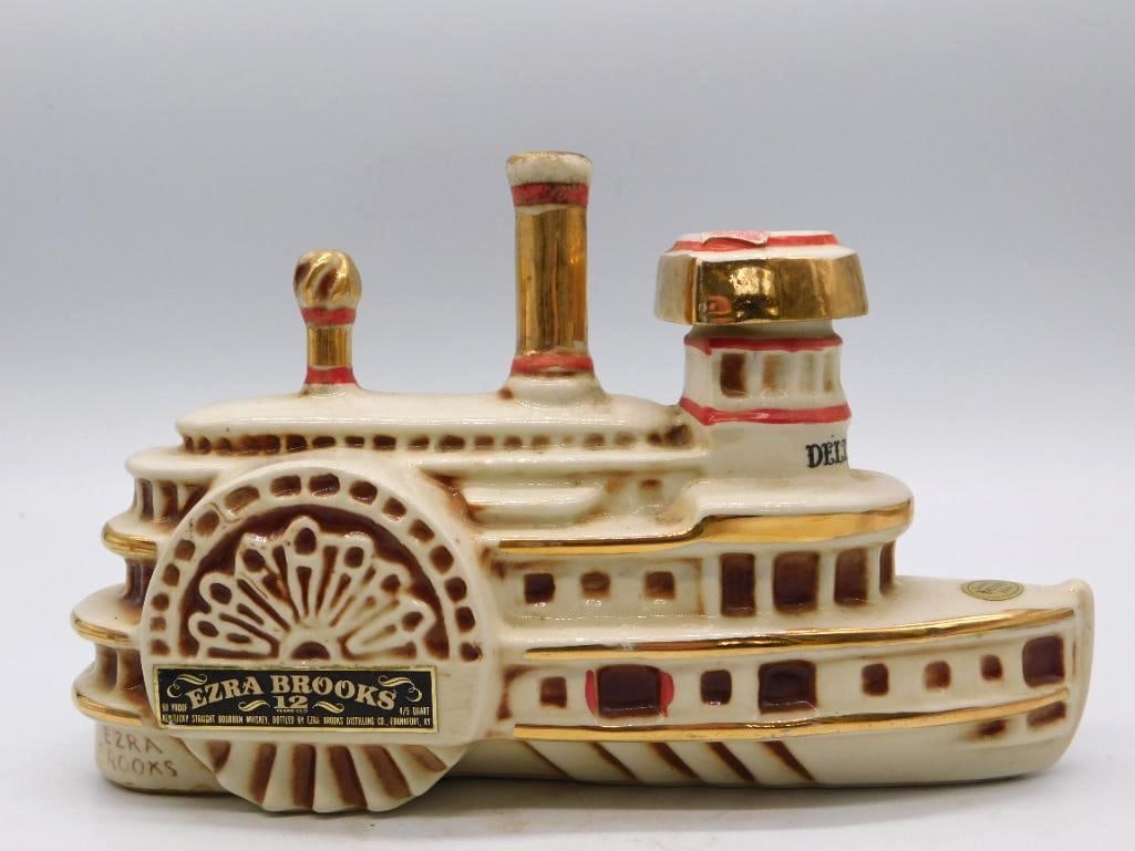 Showboat Riverboat Whiskey Decanter 1969 Seal Intact: A cream and gold ceramic decanter modeled as a riverboat showboat complete with paddle wheel and twin smokestacks. Marked 1969 to the base and fitted with a federal tax stamp. A lively piece in the