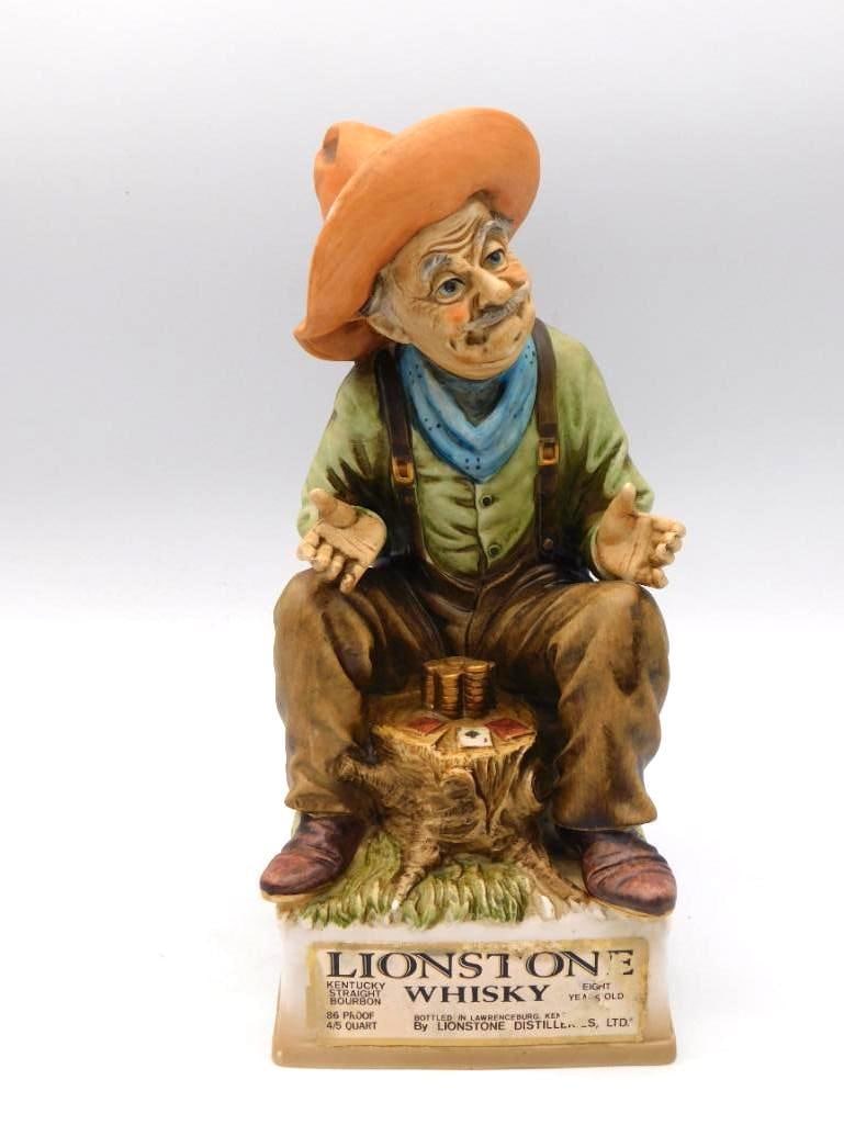 Lionstone Lucky Buck Old West Gambler Whiskey Decanter: A Lionstone Distilleries decanter modeled as Lucky Buck an Old West gambler seated upon a stump with his playing cards and a scatter of gold coins near at hand. The sculptor caught the shrewd unhurrie