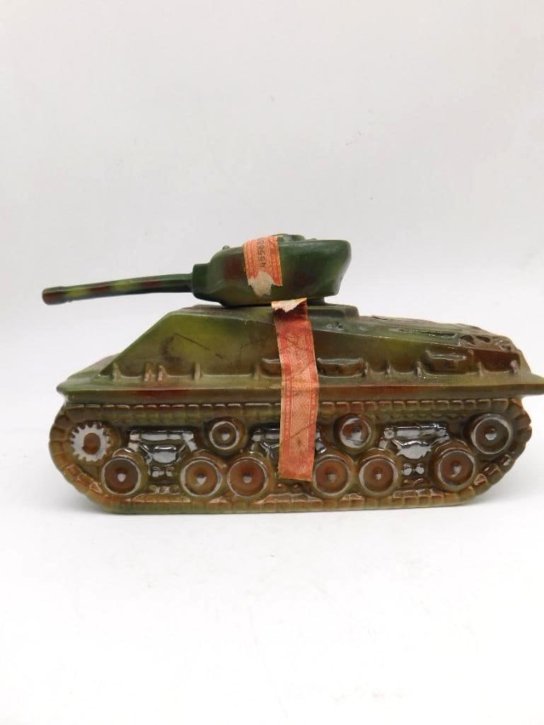 Ezra Brooks Military Tank Ceramic Bourbon Decanter: An Ezra Brooks ceramic decanter cast as an armored military tank in camouflage-tone glaze its turret and cannon modeled to look ready to swing. A stout subject and a sturdy shelf piece. The Ezra Brook