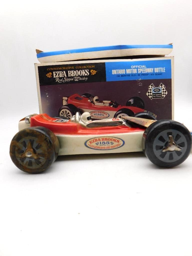 Ezra Brooks Ontario Motor Speedway Race Car Decanter with Original Box: An Ezra Brooks Heritage China decanter modeled as an Indianapolis-type race car number 10 in red and cream with a helmeted driver at the wheel and heavy black racing tires. Measures approximately 14 i