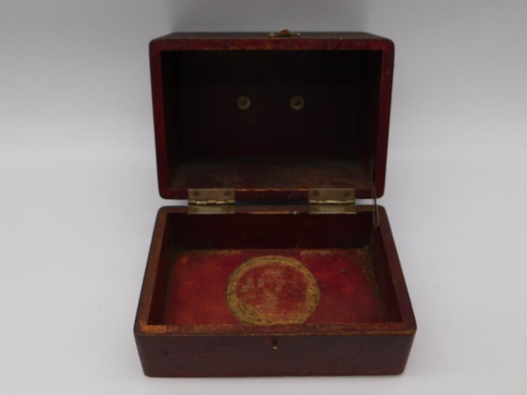 Antique Red Lacquer Wood Trinket Box: Small hinged wooden trinket box with a red lacquer-finished interior featuring a faded gilt circular medallion design. The exterior is dark stained wood with a brass hinge and hasp. Measures approxima