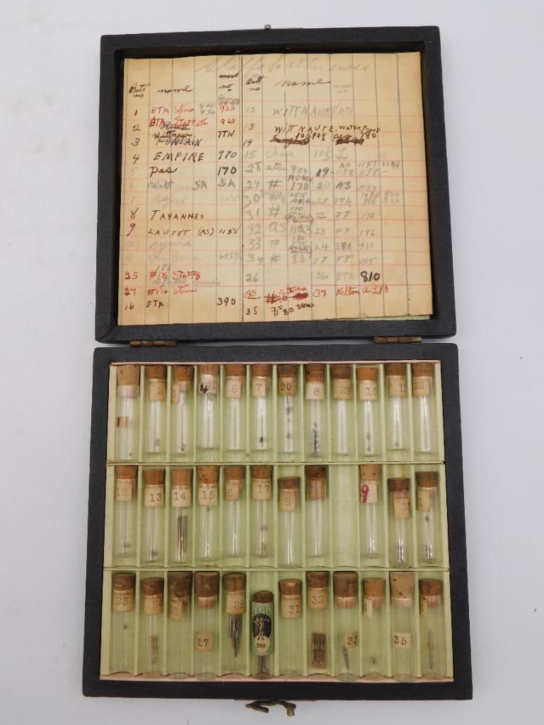 Watch Parts Box with Ledger - ETA, Wittnauer, Tavannes & More: Vintage watchmaker's parts case with a handwritten reference ledger listing bottle numbers against watch brand and caliber names including ETA, Wittnauer, Fontainmelon, Empire, Tavannes, and Lautet (A