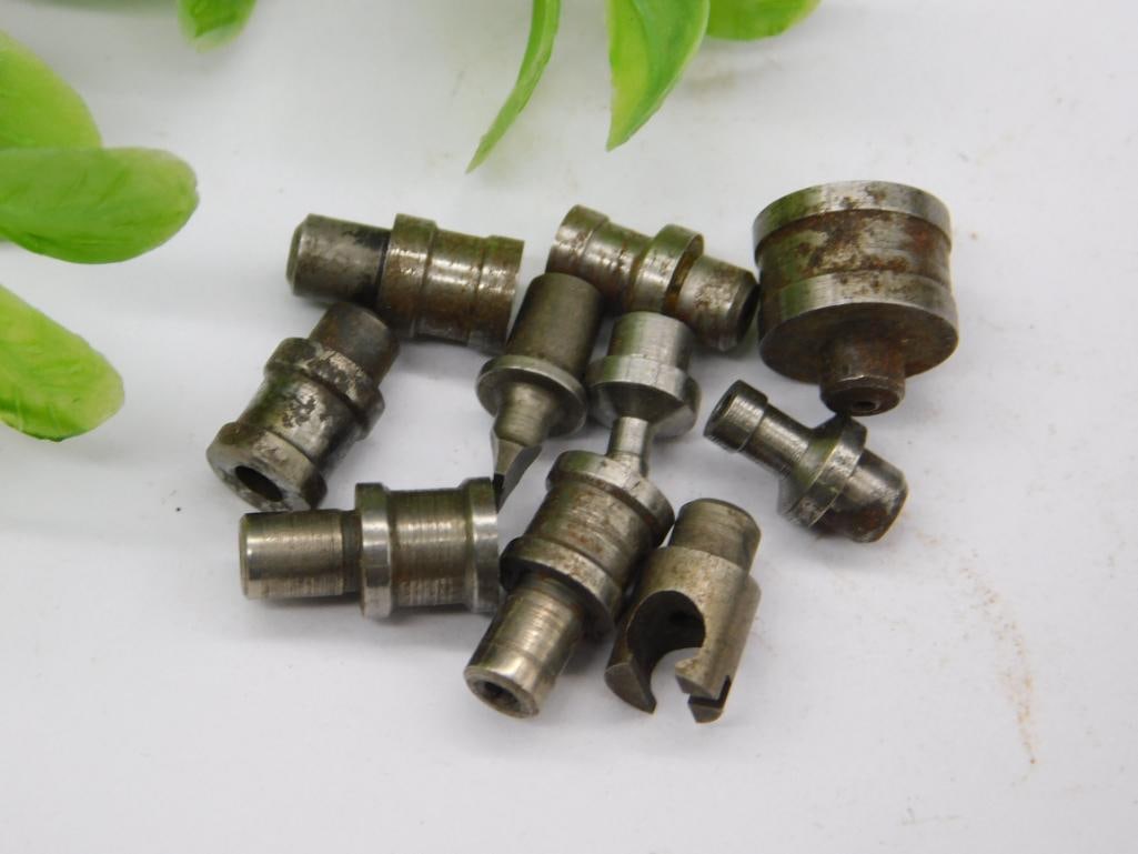 Watchmaker Staking Punches Lot with Aged Patina: Approximately ten unmarked steel watchmaker staking-set stakes of varied diameters, several showing an aged brown/rust patina while others remain bright steel. Tip shapes include flat, domed, and