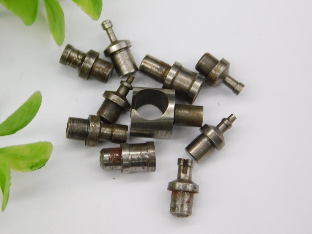Vintage Watchmaker Tool Parts with Forked Hand Remover: Lot of small machined steel parts including a domed/acorn-shaped rusty piece and two open forked-end pieces resembling watch hand-pulling or pallet-fork tools, along with several stepped-shaft