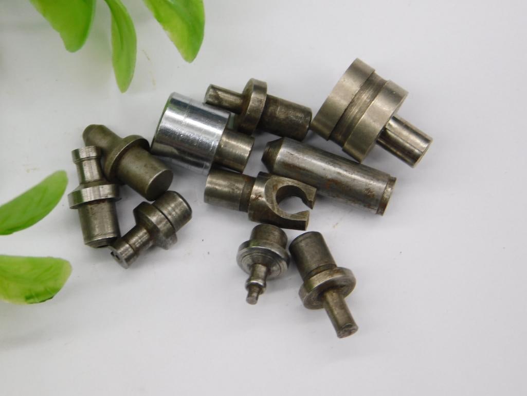 Watchmaker Staking Punches with Threaded Shanks: Approximately ten small steel components with pointed and cupped tips, several featuring threaded shanks, consistent with a watchmaker's staking tool or lathe part assortment. No legible brand or
