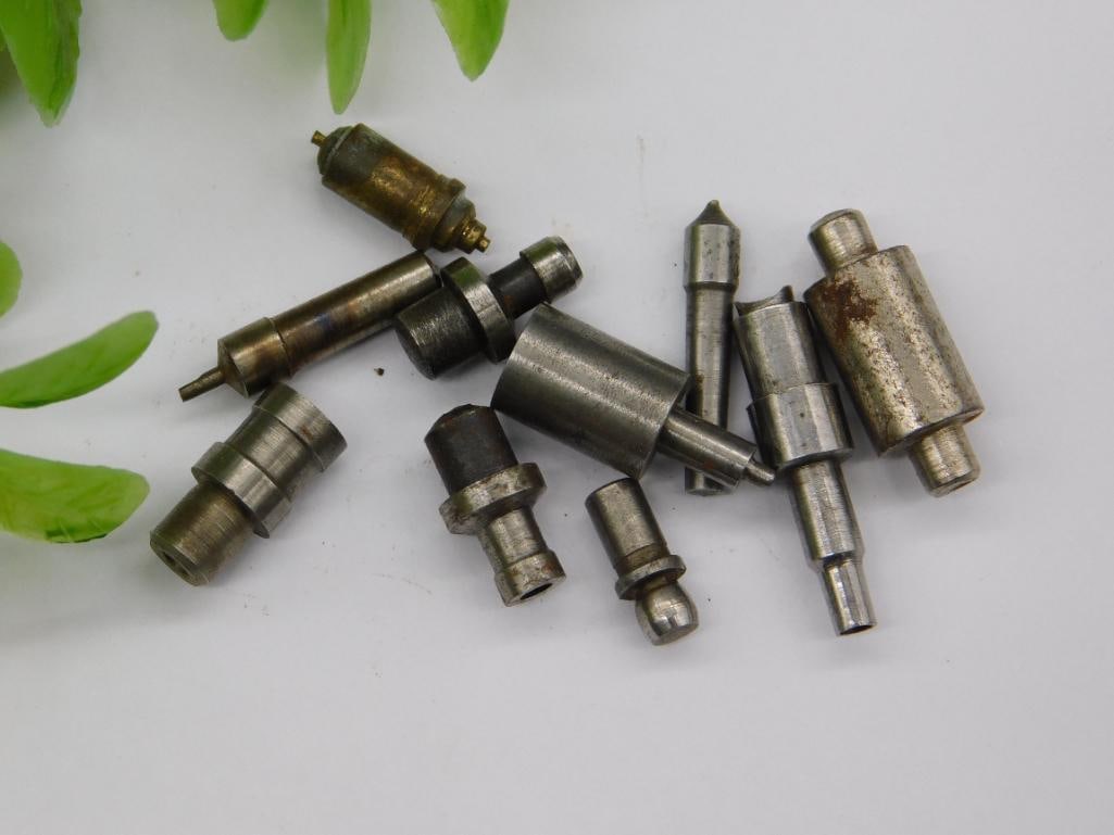 Watchmaker Tool Parts Lot with Brass Bullet-Shaped Piece: Assortment of small steel punches and stems, including a brass bullet-shaped fitting and several stepped shafts with cupped or tapered tips, likely watchmaker lathe or staking tool components. No