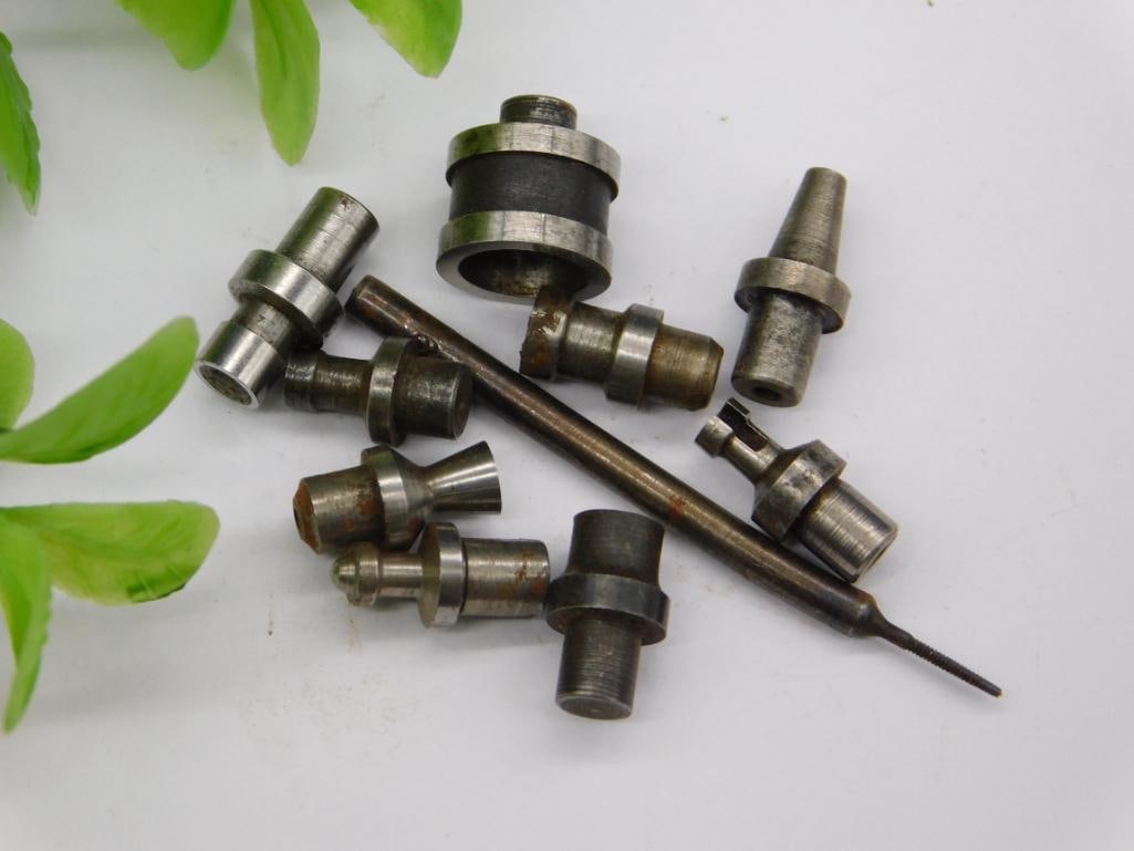 Watchmaker Staking Tool Punches with Coin Scale: Lot of small steel machined parts with pointed, cupped, and stepped-shaft tips, along with a numbered slender rod/bit. No brand markings visible; some pieces show light rust.
