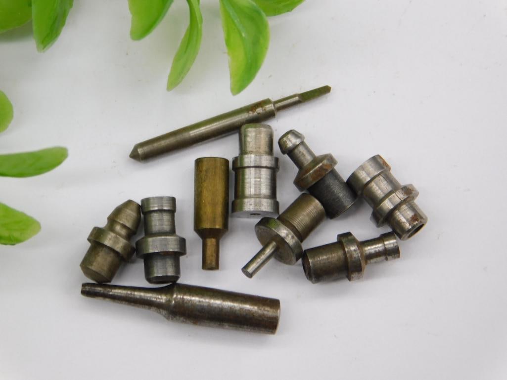 Watchmaker Staking Tool Parts with Coin Scale: Assortment of small steel machined parts with a rusted pointed rod, threaded shanks, and stepped punches with cupped or flat tips. No brand markings visible.