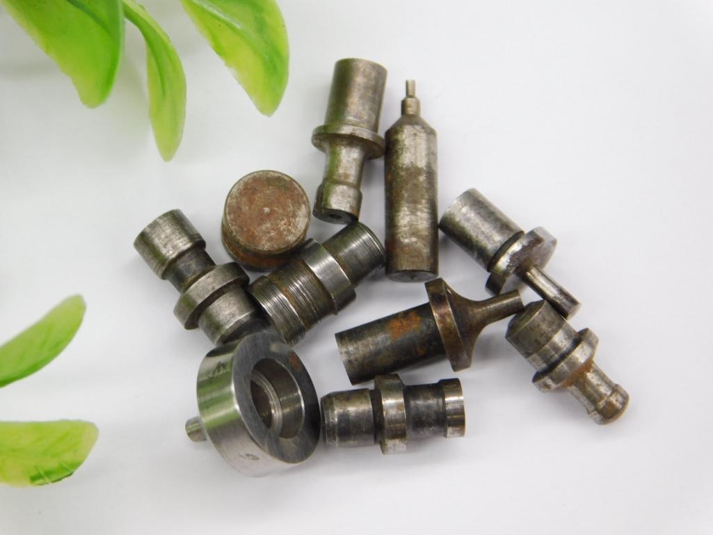 Watchmaker Tool Parts with Large Steel Washer Ring: Lot of small machined steel parts including a large flat washer/ring-shaped piece with a rusted disc insert, plus several stepped punches with pointed and cupped tips. Light rust noted on some