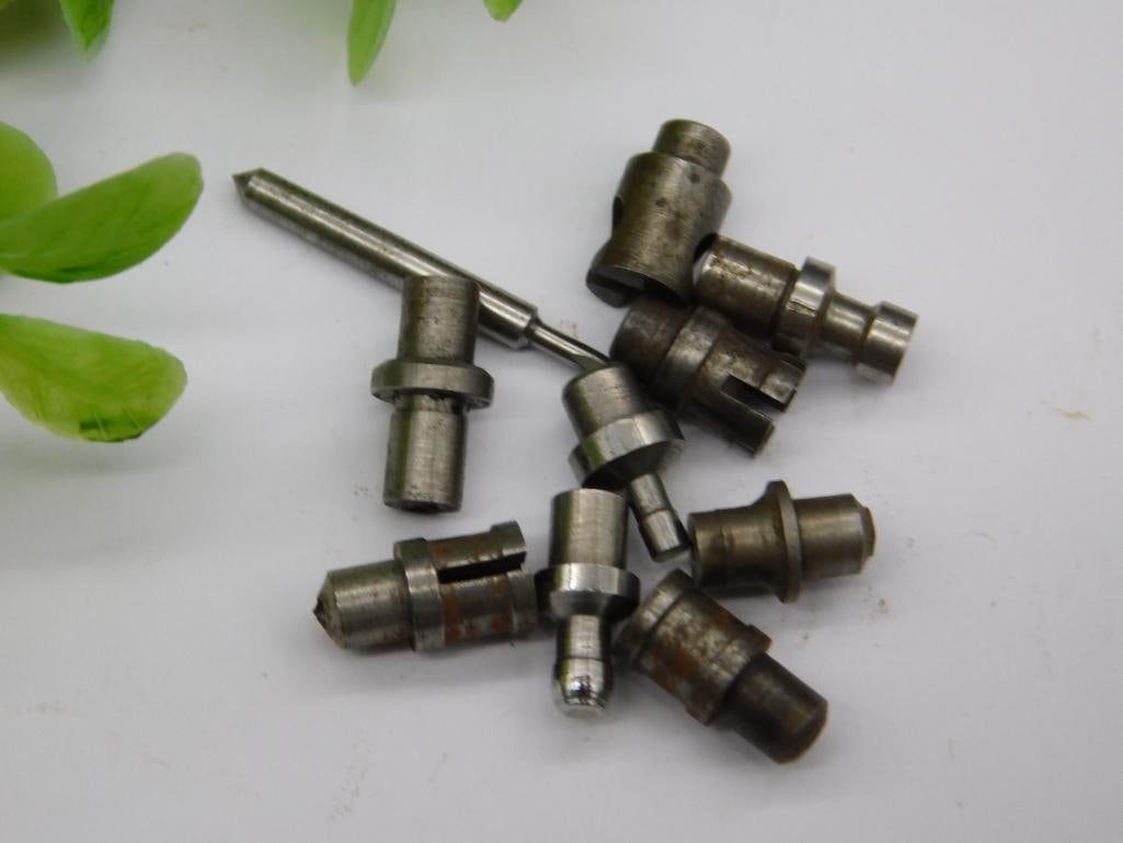 Watchmaker Staking Tool Parts with Brass Pieces & Coin: Group of small steel and brass machined parts, including knurled brass cylindrical fittings and a pointed blued-tip rod, alongside stepped punches with cupped tips.