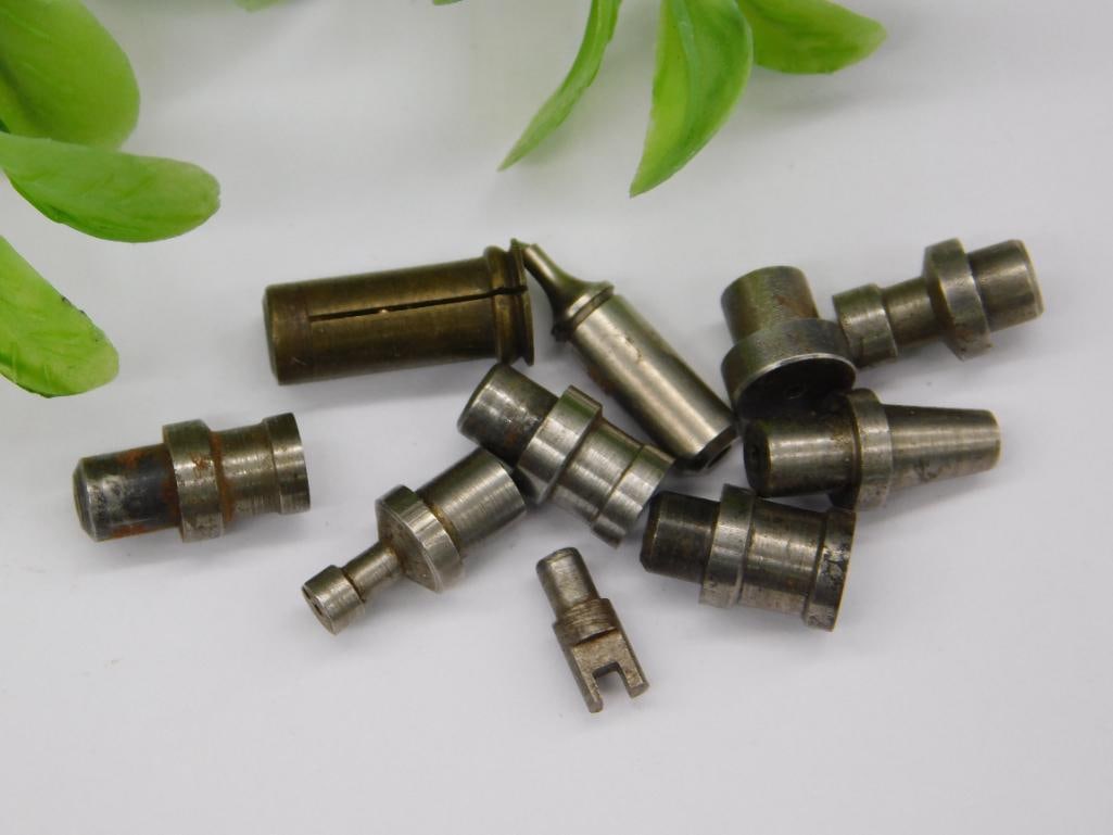 Watchmaker Staking Tool Parts with Brass Piece & Coin: Lot of small steel and brass machined parts including a brass ridged cylindrical piece, a small forked notched-tip fitting, and several stepped punches with pointed or cupped tips.