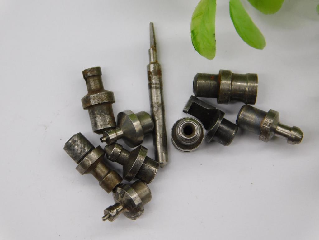 Watchmaker Tool Parts with Jewel Bearing Ring: Group of steel stepped stakes, a threaded screwdriver-style bit, a forked stake, and a small brass-and-steel jewel/bearing ring component, consistent with watchmaker lathe and staking tool