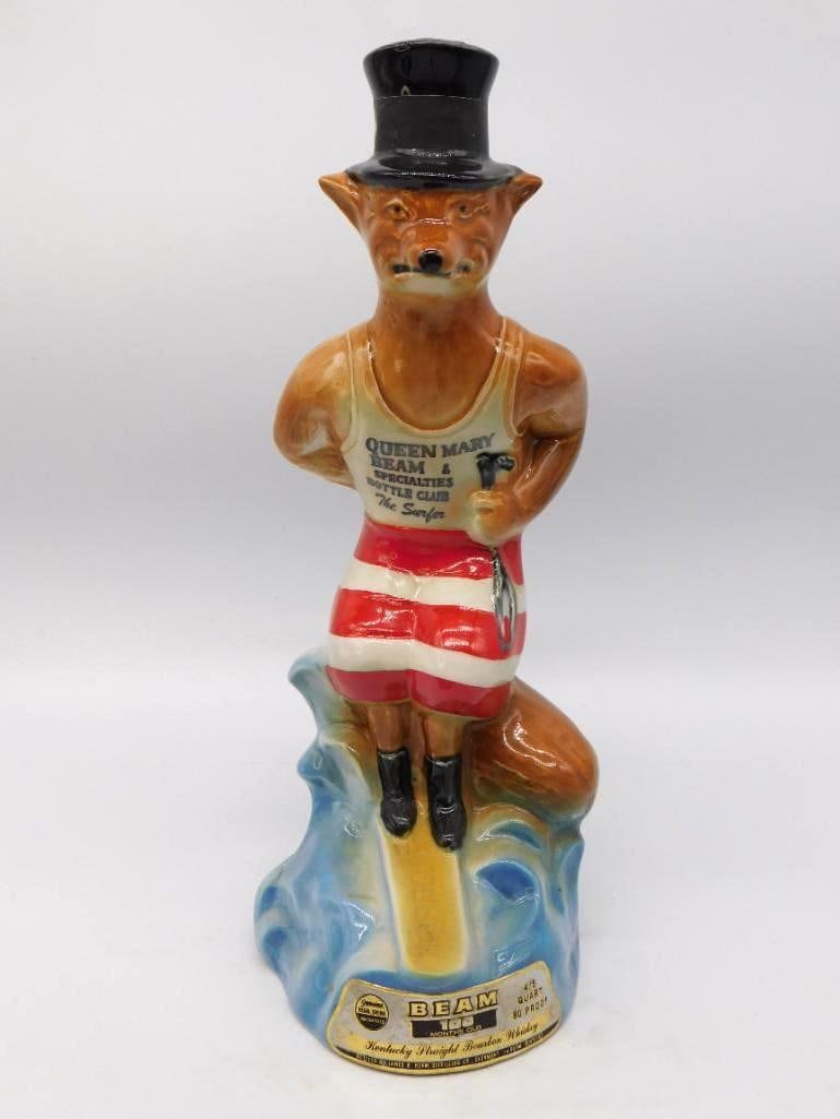 Jim Beam Queen Mary Beam Bottle Club The Surfer Fox Decanter: A lively Jim Beam club decanter shaped as a fox in a top hat and striped bathing suit issued for the Queen Mary Beam and Specialties Bottle Club as The Surfer. He stands jaunty on a curl of blue surf 