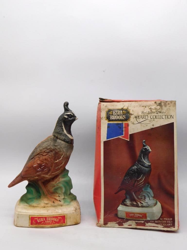 Ezra Brooks Award Collection Valley Quail Decanter with Original Box: An Ezra Brooks decanter of the Award Collection modeled as a valley quail standing alert upon a green tussock with its topknot plume curled forward. The molding of the feathers is admirable and the mu