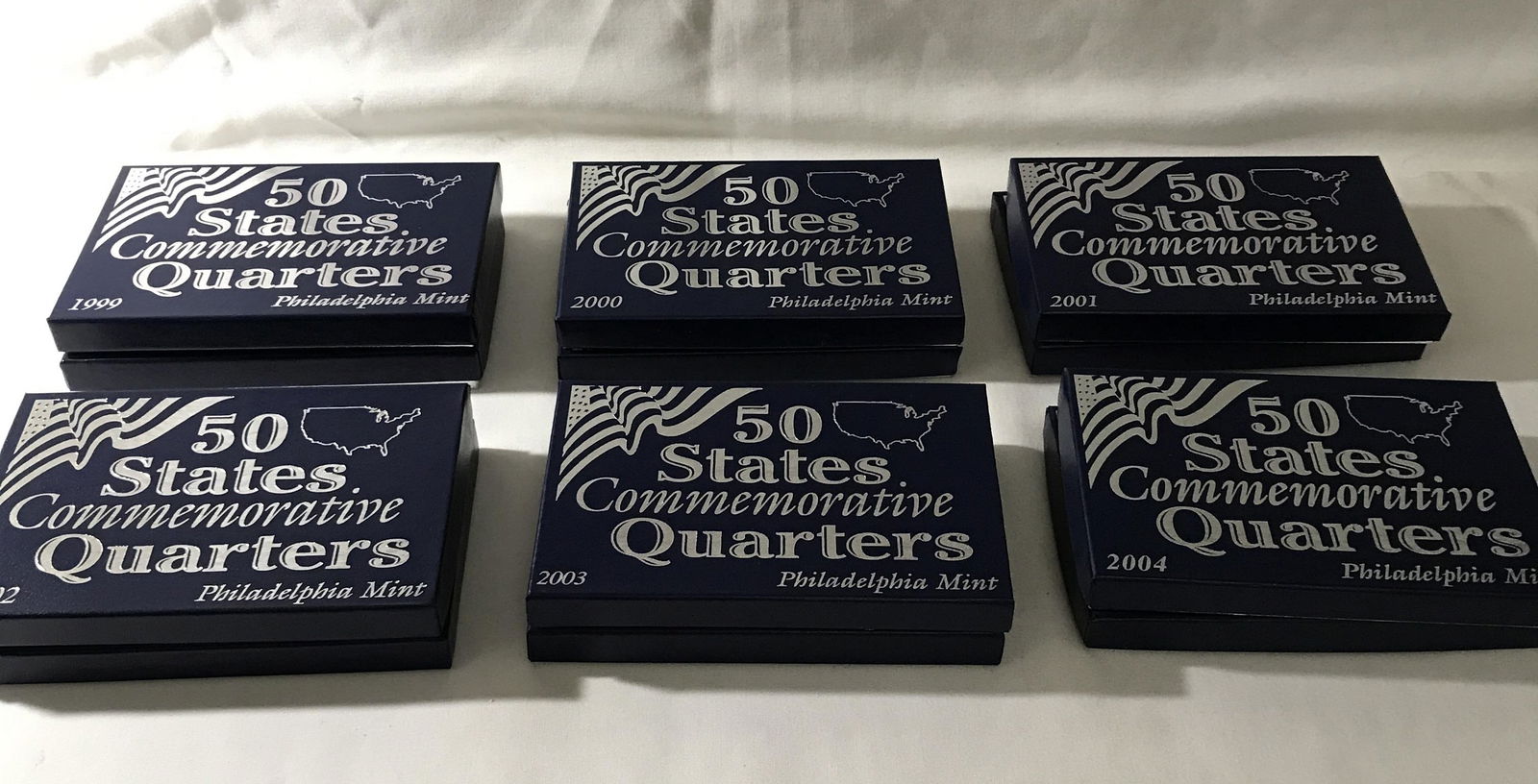 Philadelphia Mint 50 state Commemorative Quarter: years 99, 2000 2001 2002 2003 and 2004 ,not all states included ,5 quarters to each box ,12 boxes total.
