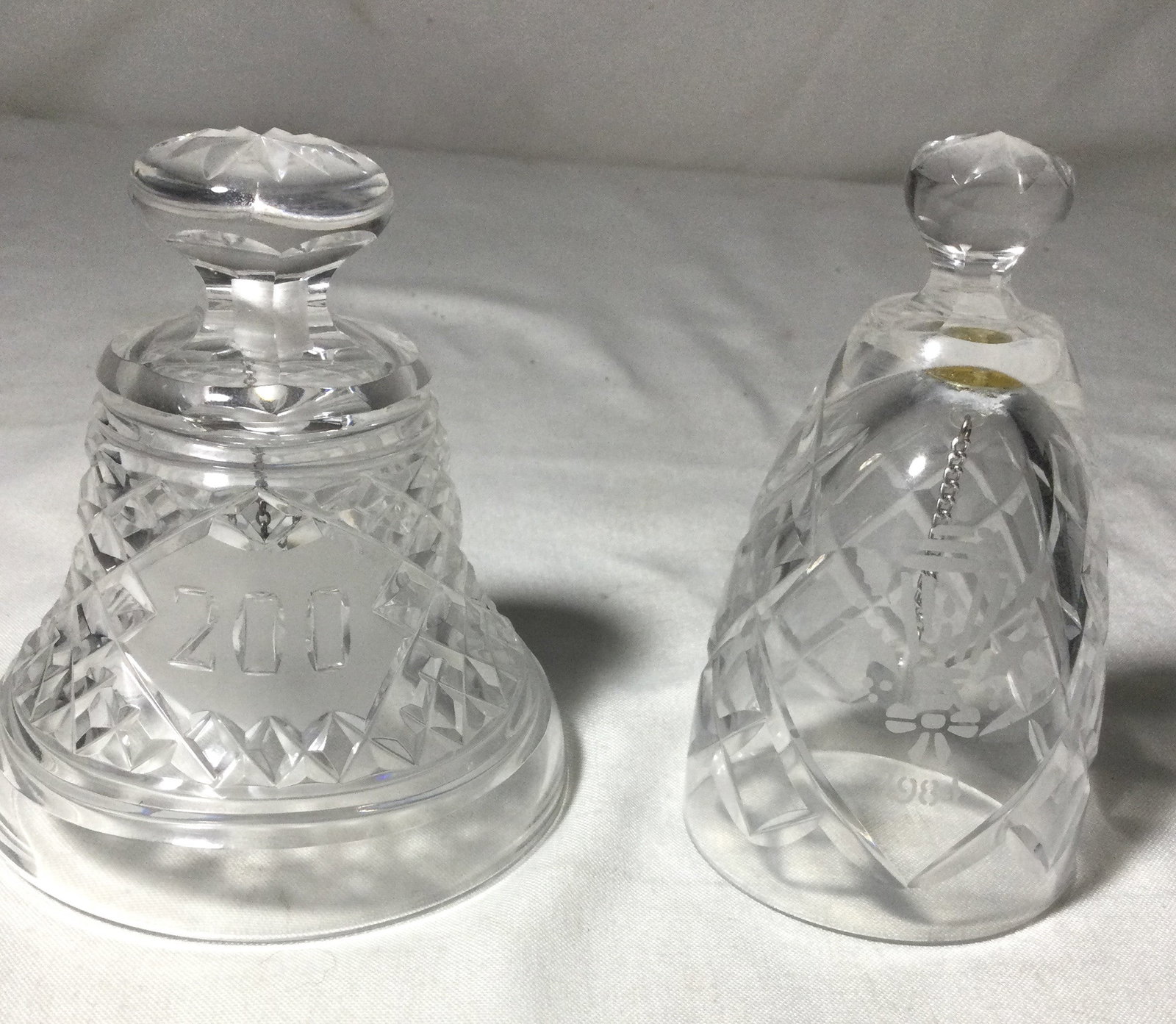 Waterford Crystal Dinner Bells (2): 1984 Holly lantern Christmas crystal bell andWaterford crystal 200th anniversary bicentennial bell, measurements are four and 4 1/2 inches tall.
