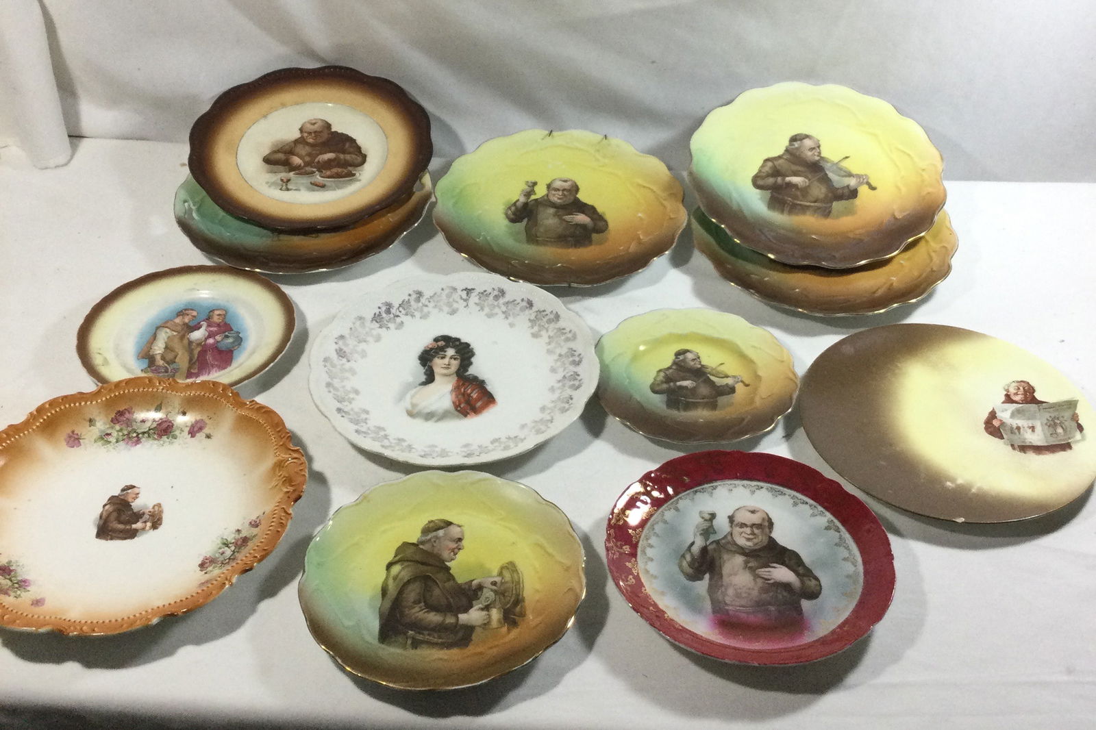 Friarware Monk Pictured Plates: 12 plates total 11 of them portrayed Friars/Monks eating ,drinking ,and playing music ,two plates are doubles ,one plate of mysterious woman with flowers in her hair, Plates measure from 7 to 10 inche