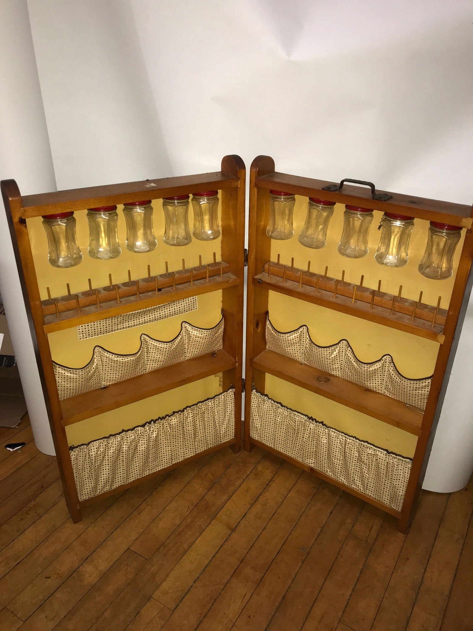 Vintage Portable Wood Sewing Spool Cabinet: Cabinet folds and has a handle at the top for portability interior features storage, including bottles for buttons, measures 31 x 18 inches folded