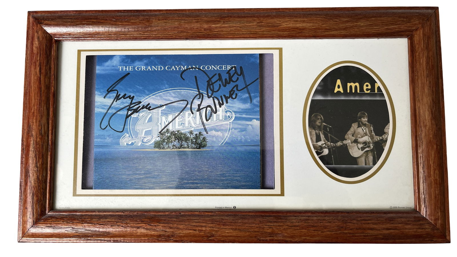 AMERICA BAND SIGNED THE GRAND CAYMAN CONCERT CD INSERT AND PERFORMANCE PHOTO FRAMED DISPLAY: This music memorabilia lot features a framed display dedicated to the legendary folk-rock band America. The centerpiece is a CD insert for the album The Grand Cayman Concert, signed in bold black