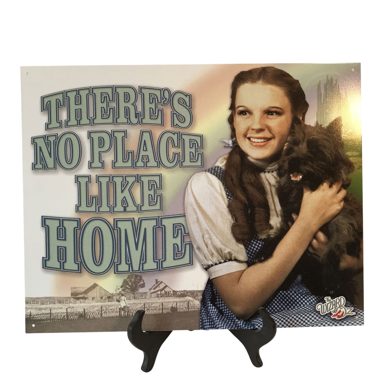 Desperate Enterprises The Wizard of Oz There's No Place Like Home Tin Sign: This is a decorative metal wall sign produced by Desperate Enterprises, Inc. and officially licensed by Turner Entertainment Co. and features a colorized image of Judy Garland as Dorothy Gale holding