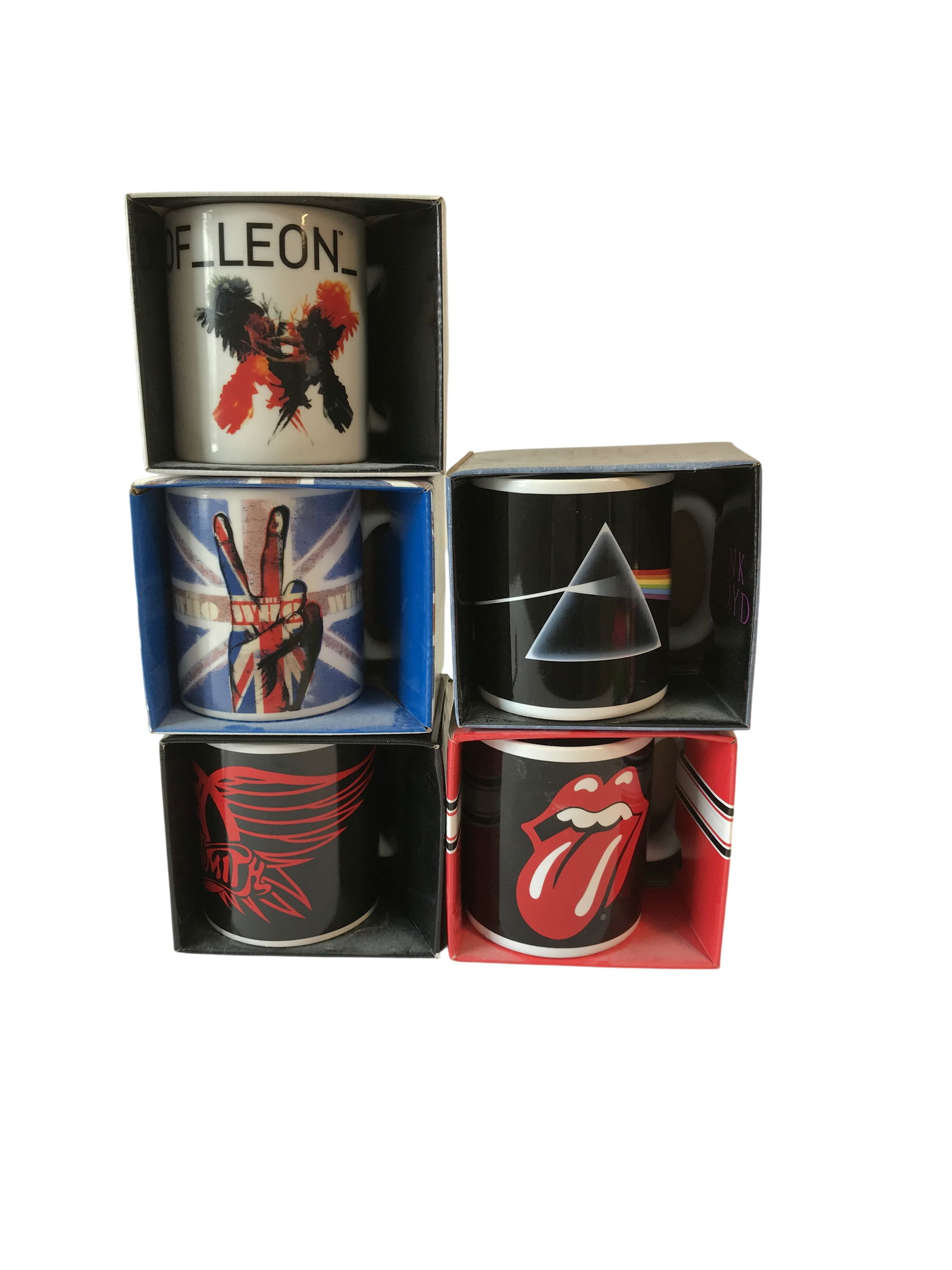 A Collection of Five Licensed Rock Band Ceramic Mugs in Original Packaging: The collection includes a white Kings of Leon mug with a black and red bird graphic, a white The Who mug with a peace sign and Union Jack graphic, a black Pink Floyd mug with the Dark Side of the