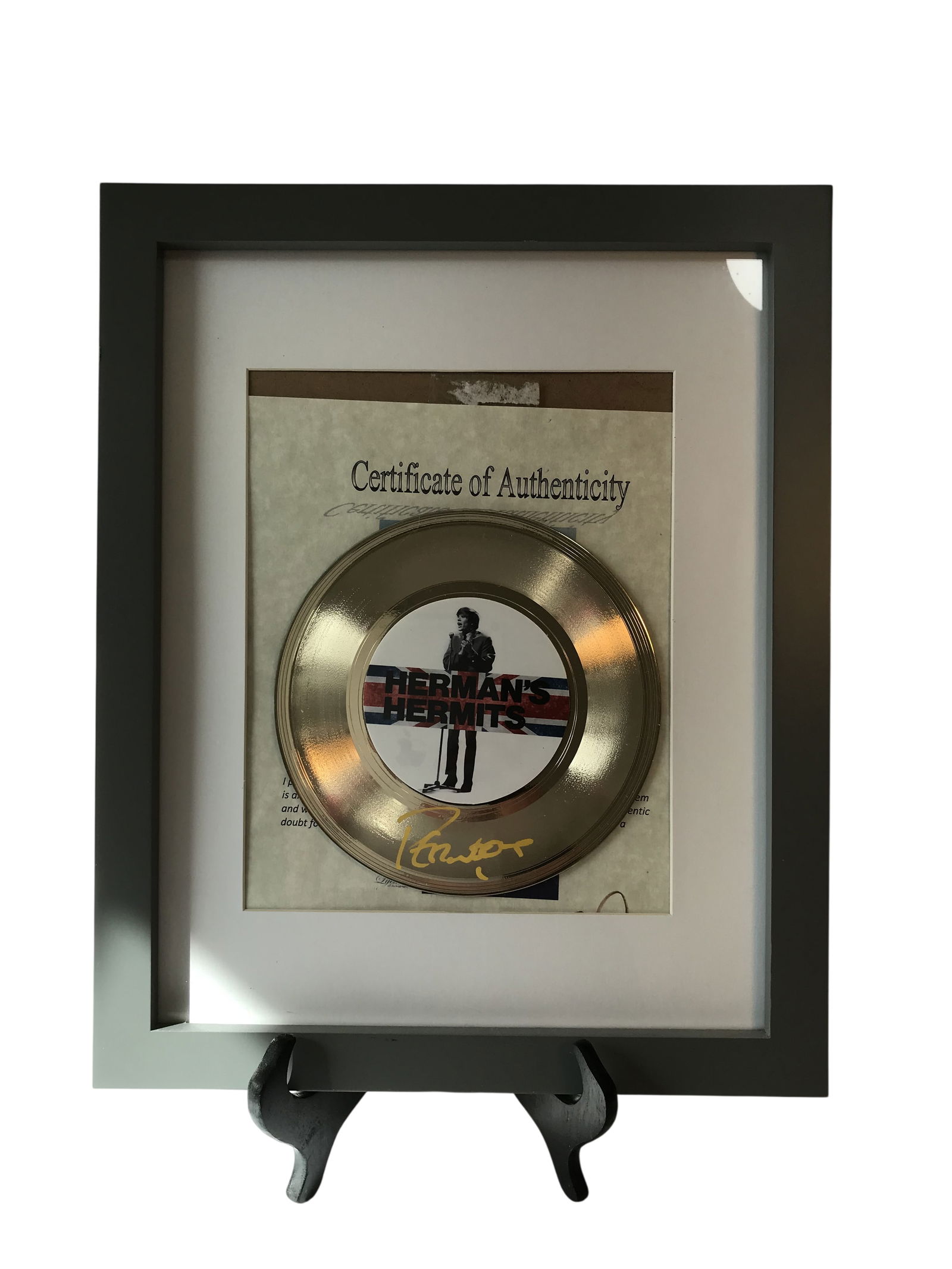 Herman's Hermits Autographed Gold-Tone Record Display: Looks like Peter Noone's signature, does have Certificate of Authenticity, This framed music memorabilia features a gold-tone record related to the British Invasion band Herman's Hermits. The display