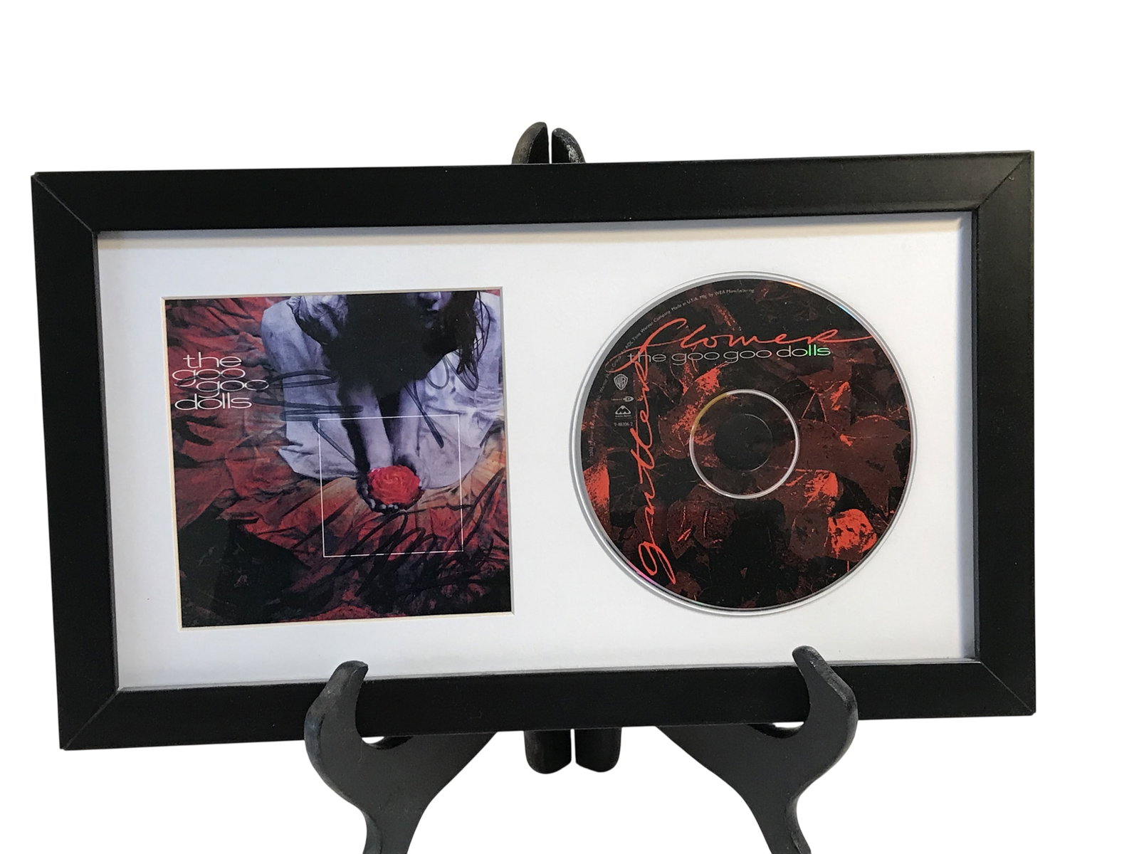 Framed Goo Goo Dolls Gutterflower CD and Signed Album Booklet: This framed music memorabilia display features the Goo Goo Dolls album Gutterflower, released in 2002 by Warner Bros. Records and Metal Blade Records. The display contains the album compact disc and t