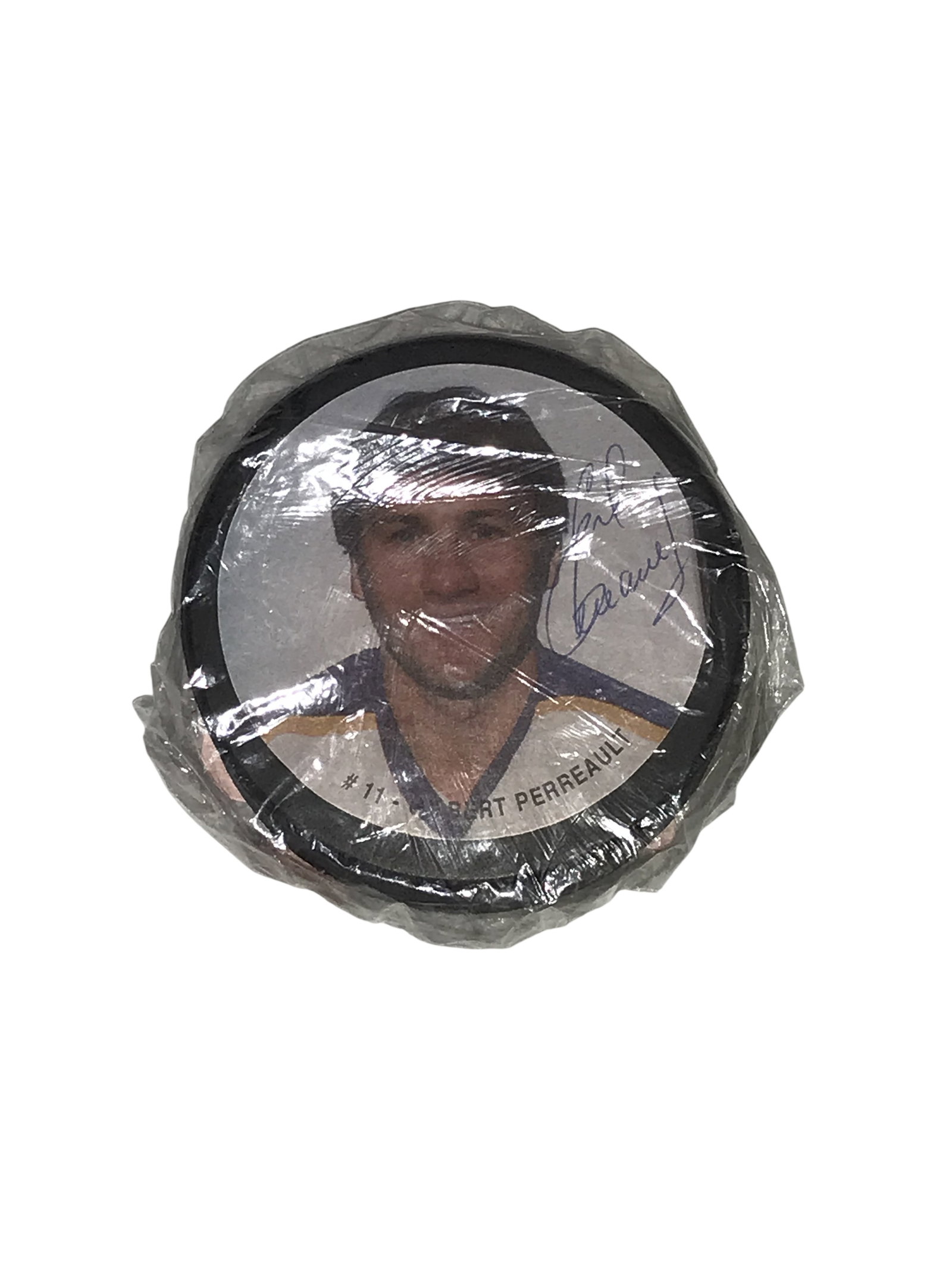 Signed Gilbert Perreault Buffalo Sabres Souvenir Portrait Hockey Puck: Souvenir portrait hockey puck featuring Buffalo Sabres Hall of Famer Gilbert Perreault, circa 1970s-1980s. The face displays a color portrait with printed text and a signature in blue ink. The reverse
