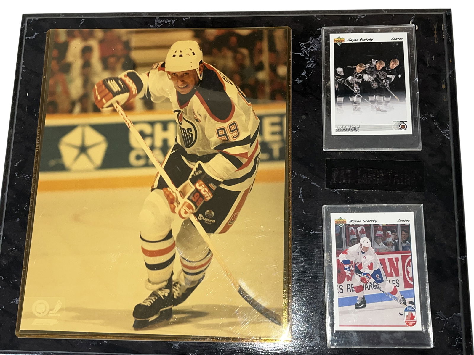 Wayne Gretzky Sports Memorabilia Plaque with 1991-92 Upper Deck Trading Cards: Wayne Gretzky sports memorabilia plaque, circa 1992. The assembly features a central metallic-finish photograph of Gretzky in an Edmonton Oilers uniform flanked by two 1991-92 Upper Deck trading cards