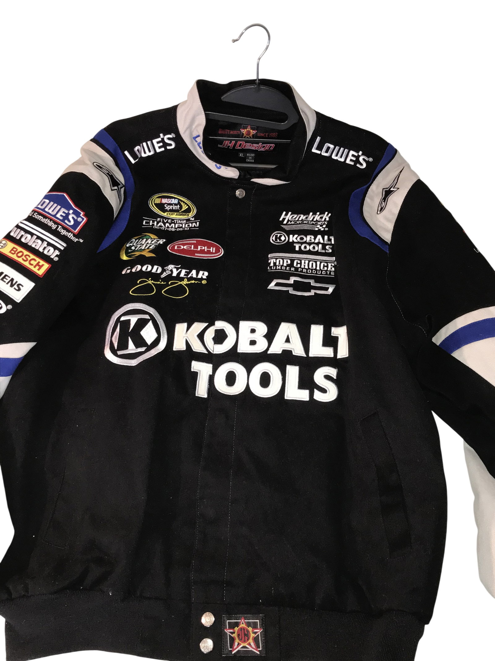 JH Design Jimmie Johnson Lowe's Kobalt Tools NASCAR Racing Jacket: JH Design NASCAR team jacket commemorating Jimmie Johnson as a five-time Sprint Cup Series champion, circa 2011. Features extensive embroidered sponsorship logos. Interior neck features a JH Design ma