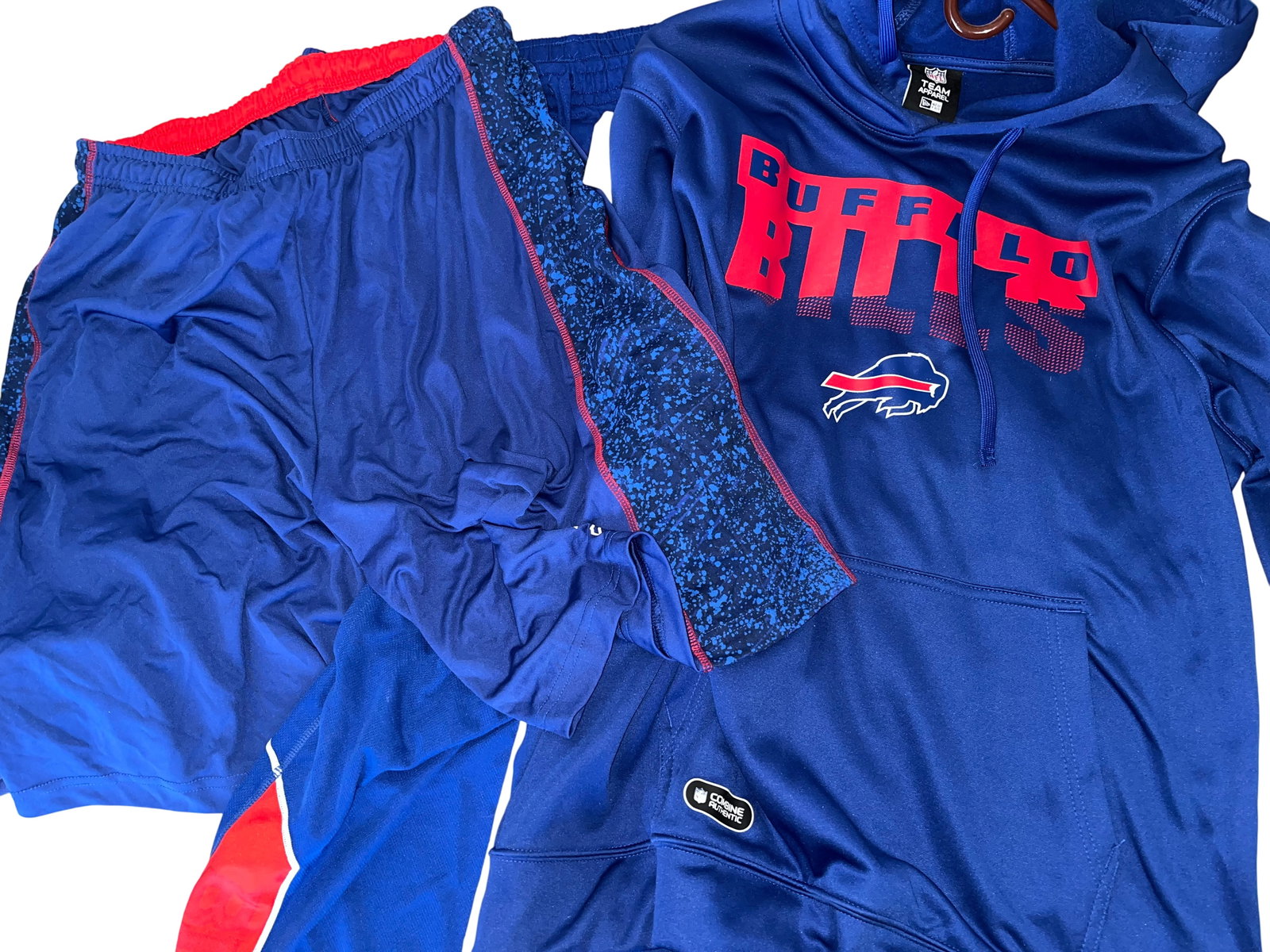 Buffalo Bills Team Apparel Collection, Five Pieces, Unsigned: This lot features a diverse collection of five (5) pieces of Buffalo Bills team-branded apparel, including performance-wear and fan gear. The centerpiece of the collection is a royal blue long-sleeve