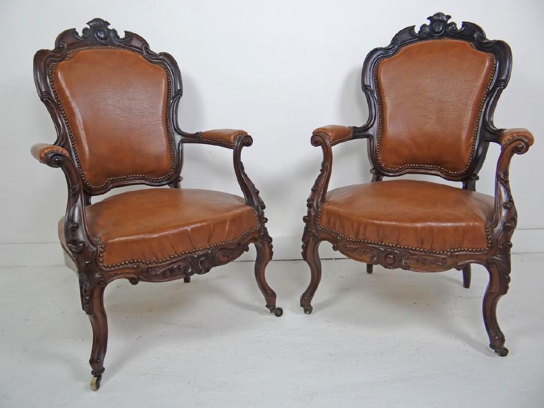 PAIR OF LOUIS XV STYLE FAUTEUILS: PAIR OF LOUIS XV STYLE FAUTEUILS WITH CARTOUCHE CARVED CHAIR BACK RAILS OVER SCROLLING CARVED ARMS AND CONFORMING SEAT FRAME RESTING ON CABRIOLE LEG COVERED IN BROWN TOBACCO LEATHER; 41"H X 25"W X 23"