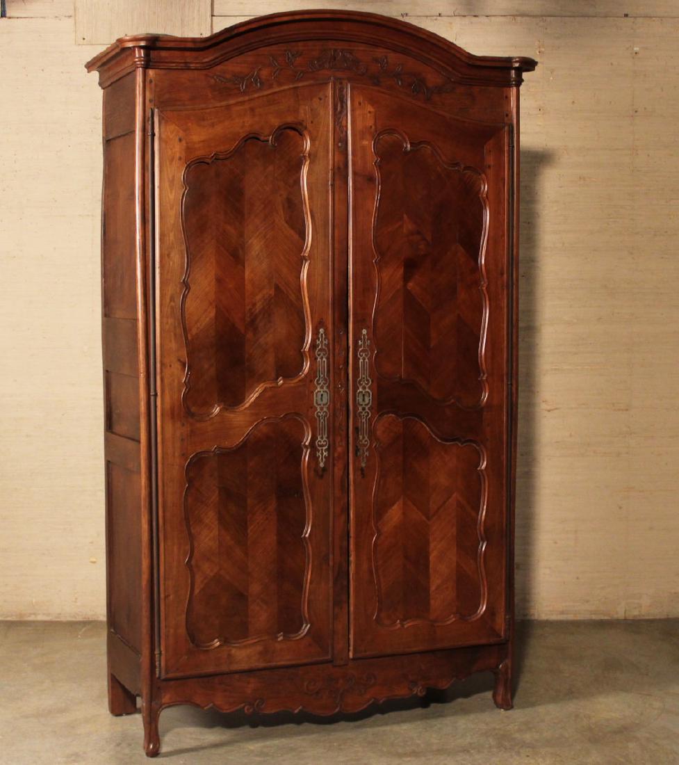 LOUIS XV STYLE MIXED FRUITWOOD ARMOIRE: LOUIS XV STYLE MIXED FRUITWOOD ARMOIRE HAVING AN ARCH MOLDED EDGE CORNICE OVER CARVED FRIEZE WITH "LOVE BIRD" SURROUNDED BY FLORAL VINES AND 2 ELONGATED SHAPED FIELDED PANEL DOORS WITH SCALLOPED CONFO