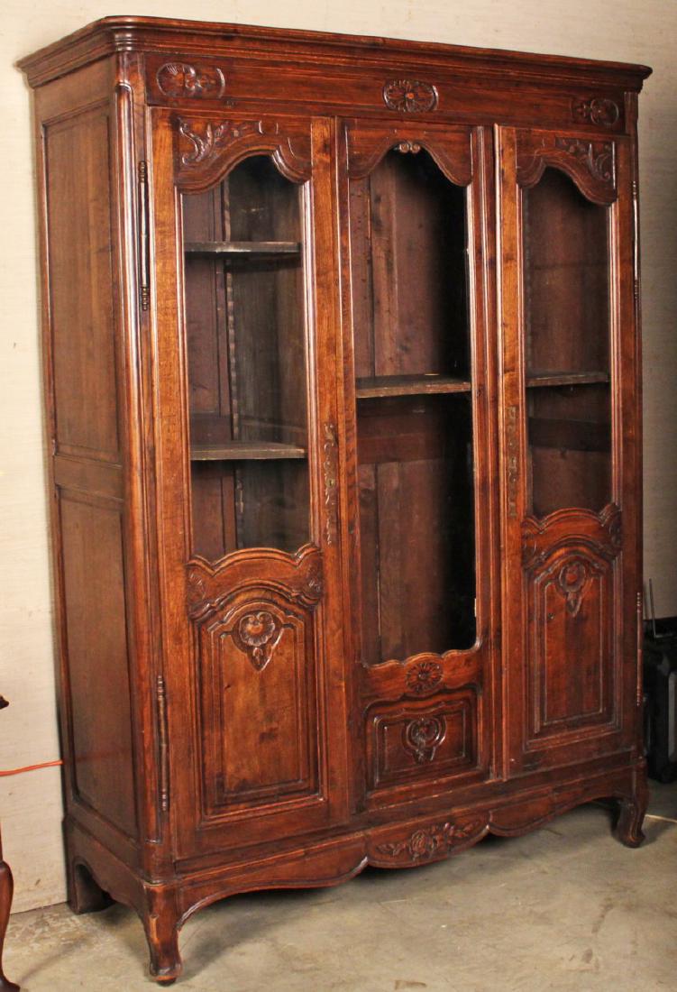 LOUIS XV STYLE CARVED OAK BIBLIOTHEQUE: LOUIS XV STYLE CARVED OAK BIBLIOTHEQUE HAVING STACK MOLDED CORNICE OVER GLASS AND RAISED PANEL DOORS ON A SCALLOPED SHAPED APRON RESTING ON CABRIOLE LEGS; 86"H X 58"W X 22"D